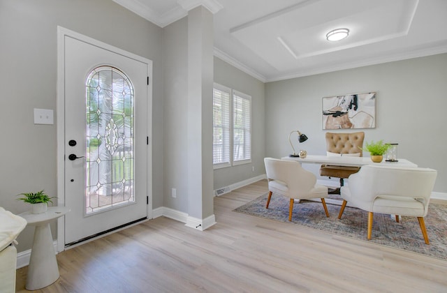 entrance foyer with baseboards, ornamental molding, wood finished floors, and visible vents