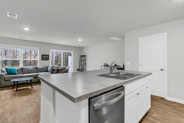 kitchen featuring light wood finished floors, visible vents, open floor plan, a sink, and dishwasher