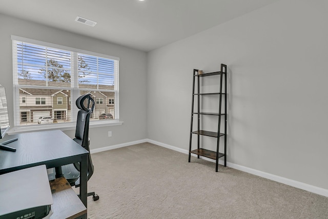 carpeted office featuring visible vents and baseboards