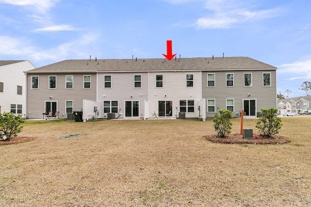 back of house with cooling unit and a yard