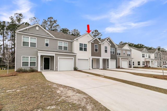 view of property with board and batten siding, a residential view, driveway, and an attached garage