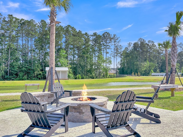 view of patio with a fire pit and a water view