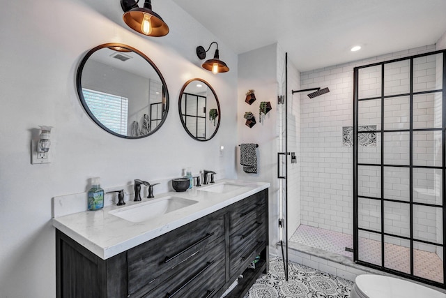 full bath with a shower stall, double vanity, visible vents, and a sink