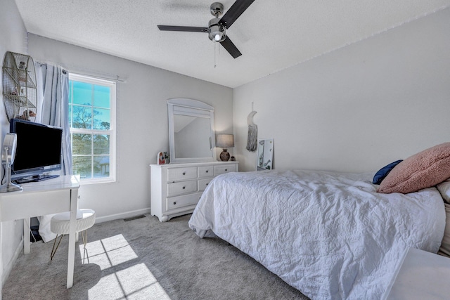 bedroom featuring baseboards, visible vents, ceiling fan, a textured ceiling, and light colored carpet