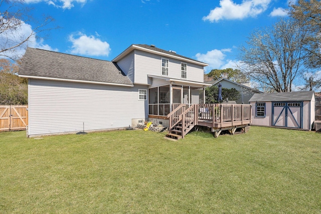 back of house with a lawn, fence, a shed, an outdoor structure, and a sunroom