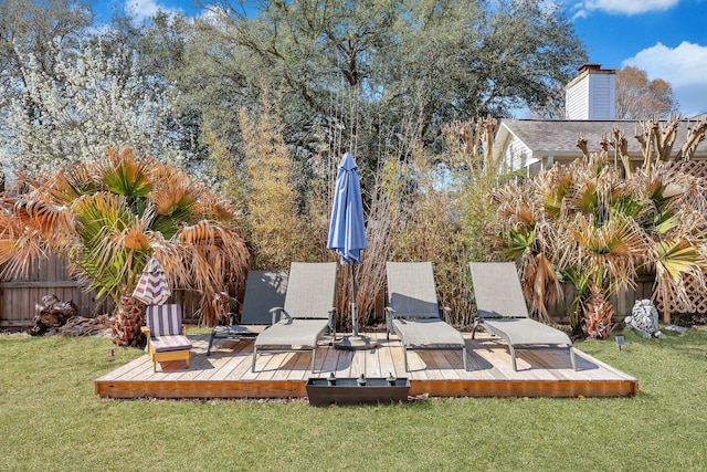 wooden terrace with a yard and fence