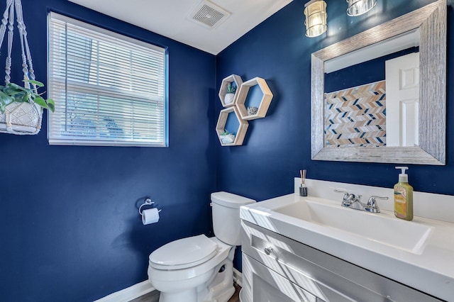 bathroom with visible vents, baseboards, toilet, and vanity