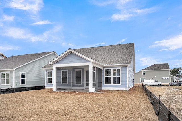 rear view of property featuring a lawn and a sunroom