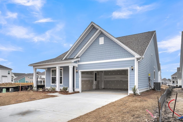 view of front of home with central AC unit, a garage, and a porch