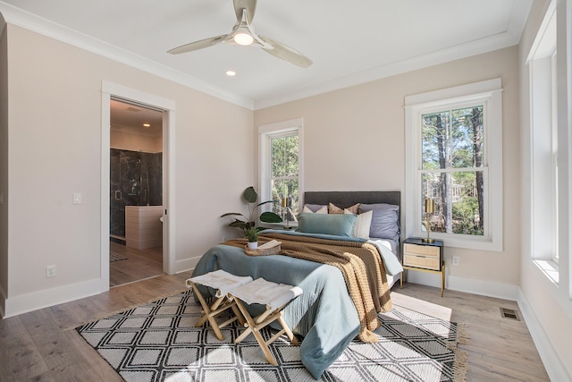 bedroom featuring light wood-type flooring, ensuite bath, crown molding, and ceiling fan