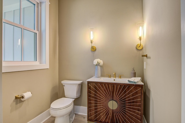 bathroom with toilet, vanity, and hardwood / wood-style floors