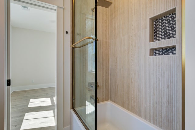 bathroom featuring washtub / shower combination and wood-type flooring