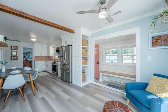 interior space with decorative backsplash, white cabinetry, light hardwood / wood-style floors, and appliances with stainless steel finishes