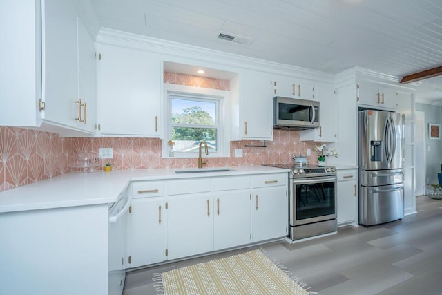 kitchen with stainless steel appliances, white cabinetry, and sink