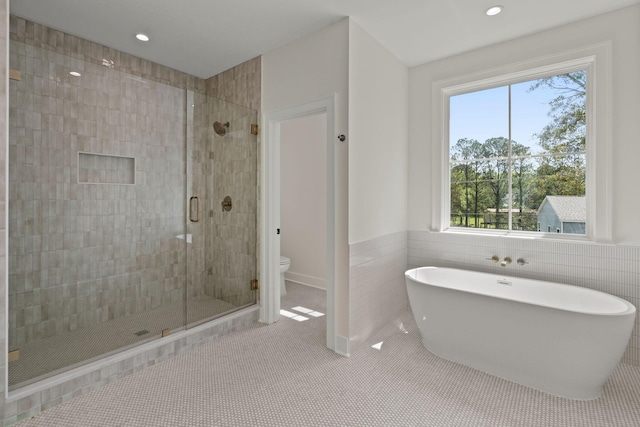 full bath featuring tile patterned flooring, recessed lighting, toilet, a shower stall, and a soaking tub