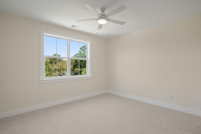 unfurnished room with light carpet, baseboards, visible vents, and a ceiling fan