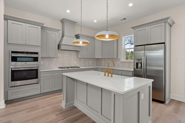 kitchen with gray cabinets, backsplash, custom range hood, and appliances with stainless steel finishes