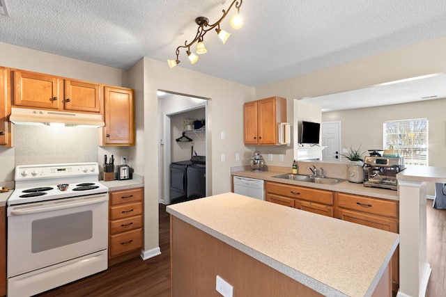 kitchen featuring separate washer and dryer, sink, a textured ceiling, and white appliances