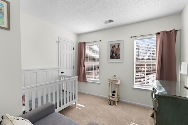 bedroom featuring light colored carpet and a textured ceiling