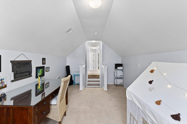 office space with lofted ceiling, light carpet, and a textured ceiling