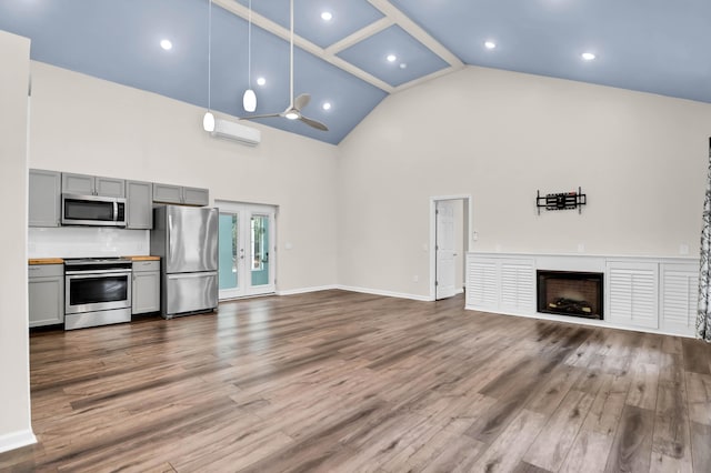 5233 Maybank Hwy, Wadmalaw Island, SC 29487 - unfurnished living room featuring high vaulted ceiling, a wall mounted AC, dark wood finished floors, a fireplace, and french doors