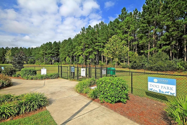 surrounding community with a gate, fence, and a lawn