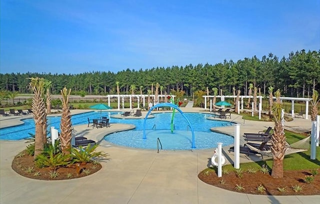 pool with a forest view and a patio