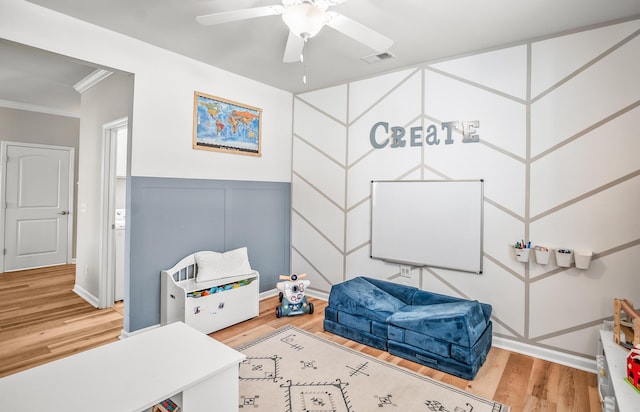 153 Glory Rd, Beaufort, SC 29906 - bedroom with wood finished floors, ornamental molding, a decorative wall, a ceiling fan, and a wainscoted wall