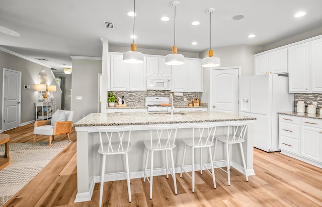 153 Glory Rd, Beaufort, SC 29906 - kitchen with white appliances, tasteful backsplash, an island with sink, light wood finished floors, and ornamental molding