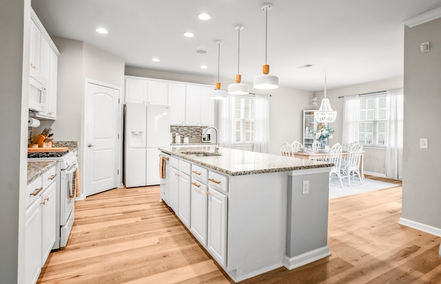 153 Glory Rd, Beaufort, SC 29906 - kitchen featuring white appliances, light wood-type flooring, white cabinetry, a center island with sink, and recessed lighting