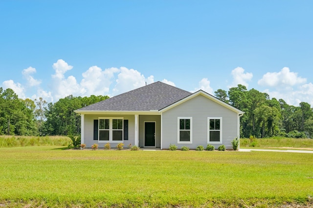 ranch-style home with a shingled roof and a front yard