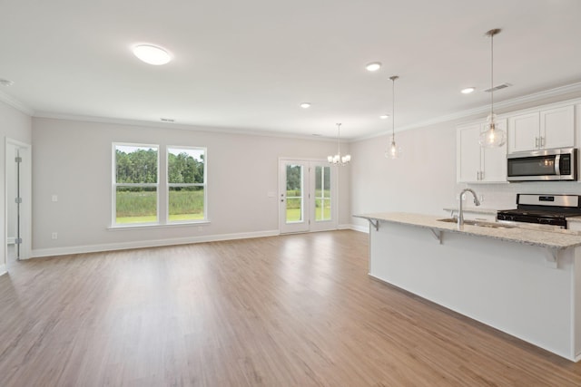 kitchen with light wood finished floors, visible vents, appliances with stainless steel finishes, ornamental molding, and a sink