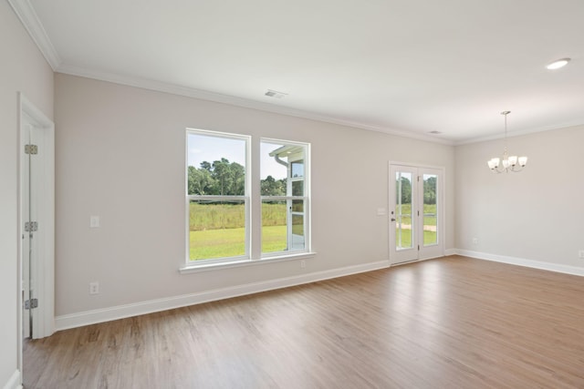 empty room with light wood-style floors, crown molding, and baseboards