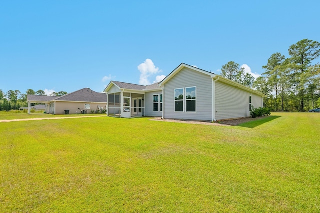 rear view of property with a sunroom and a lawn