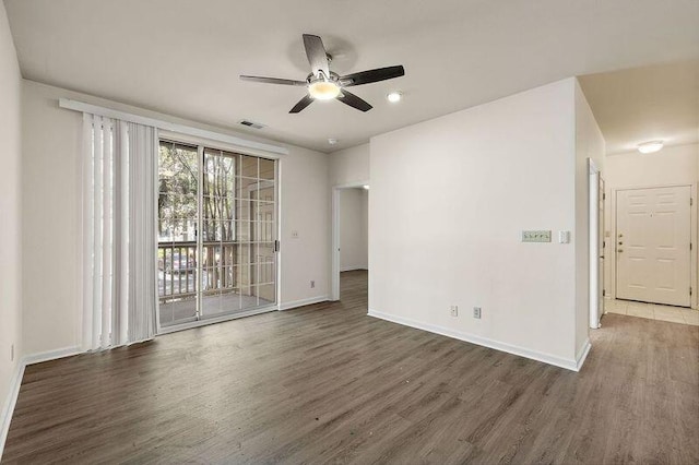 spare room with visible vents, a ceiling fan, baseboards, and wood finished floors