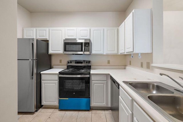 kitchen featuring a sink, appliances with stainless steel finishes, white cabinets, light countertops, and light tile patterned floors