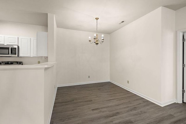 unfurnished dining area with an inviting chandelier, dark wood-style floors, baseboards, and visible vents