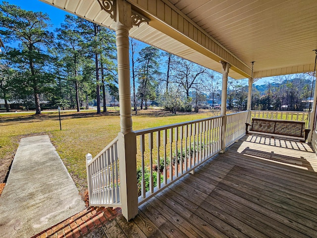 deck featuring a yard and covered porch