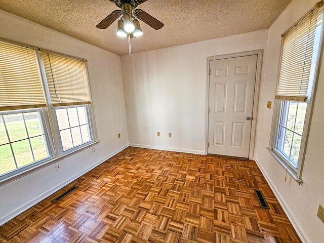 spare room featuring visible vents, a wealth of natural light, and a textured ceiling