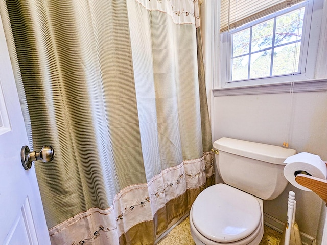 full bath with toilet and a shower with shower curtain