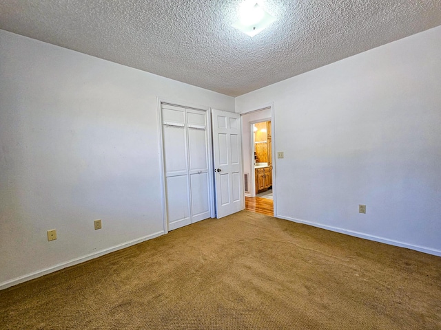 unfurnished bedroom with a closet, baseboards, carpet, and a textured ceiling