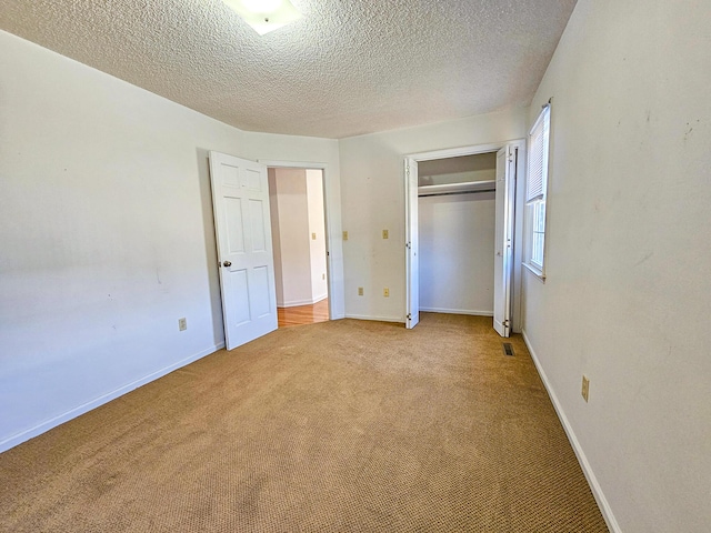 unfurnished bedroom with light colored carpet, baseboards, and a closet