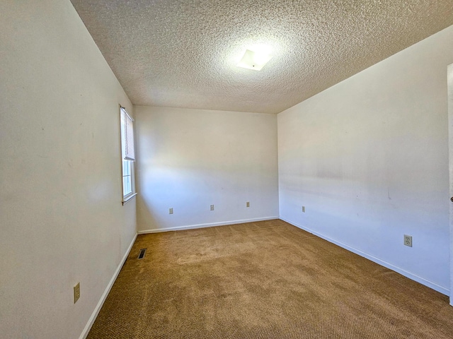 unfurnished room with visible vents, baseboards, a textured ceiling, and carpet flooring