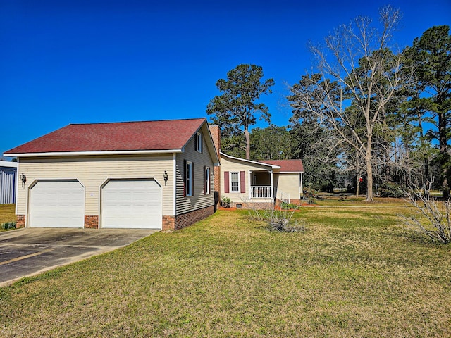 view of front facade featuring driveway, covered porch, a chimney, a front lawn, and crawl space