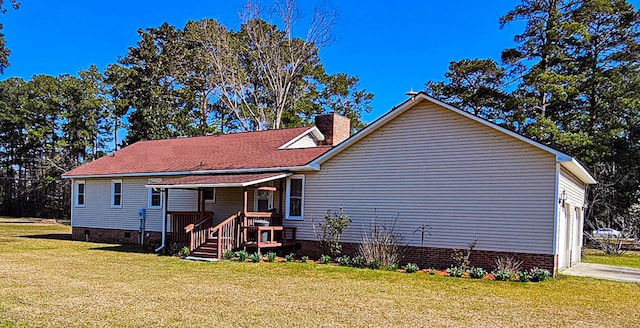 rear view of property with crawl space, a lawn, a porch, and a chimney