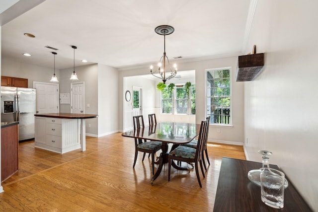 dining area featuring baseboards, light wood-type flooring, ornamental molding, a chandelier, and recessed lighting