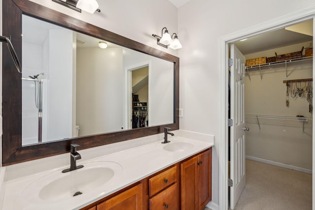 full bath featuring double vanity, toilet, and a walk in closet