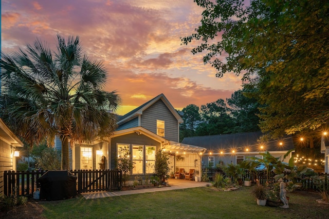 back of house at dusk with a patio area