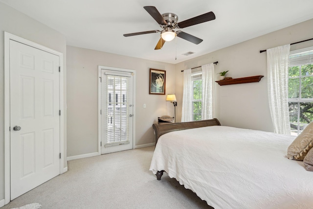 carpeted bedroom with access to exterior, multiple windows, and baseboards