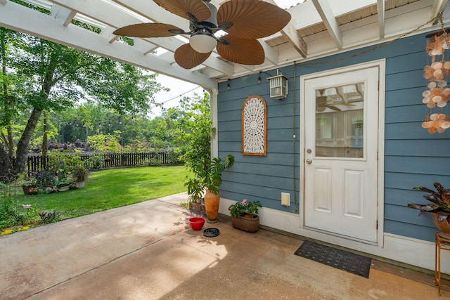 view of exterior entry featuring ceiling fan and a patio
